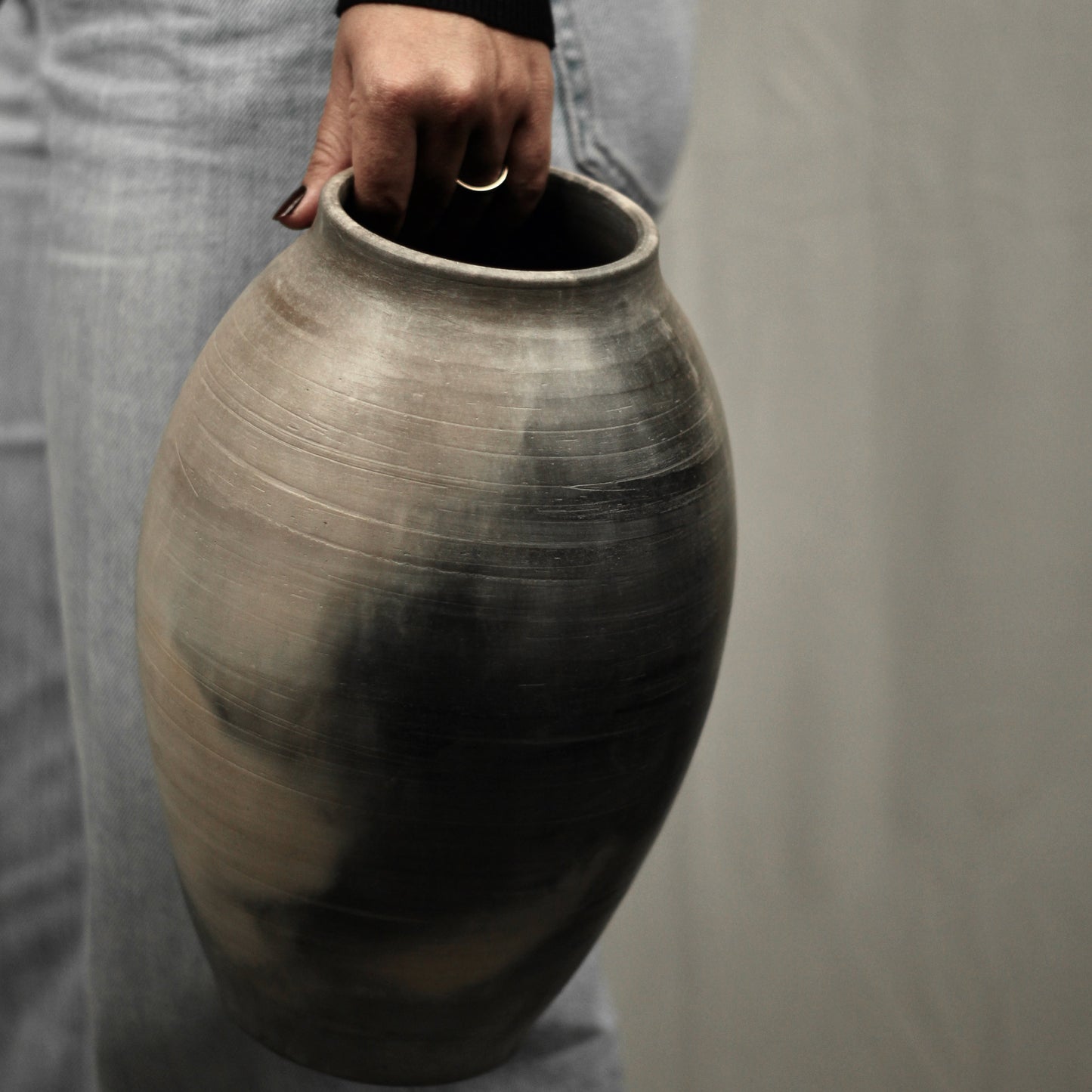 Person holding a large kaari vase against a neutral background