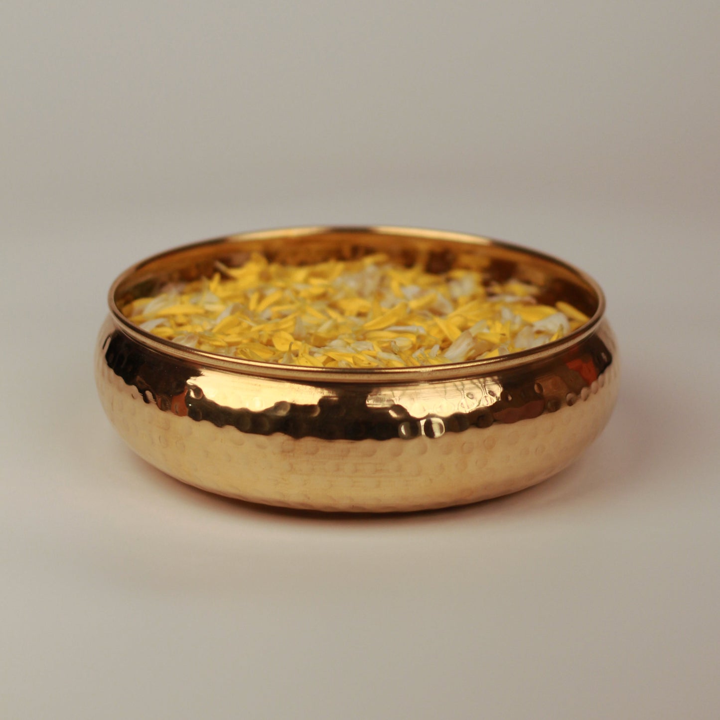 Taksh brass bowl placed on a neutral background