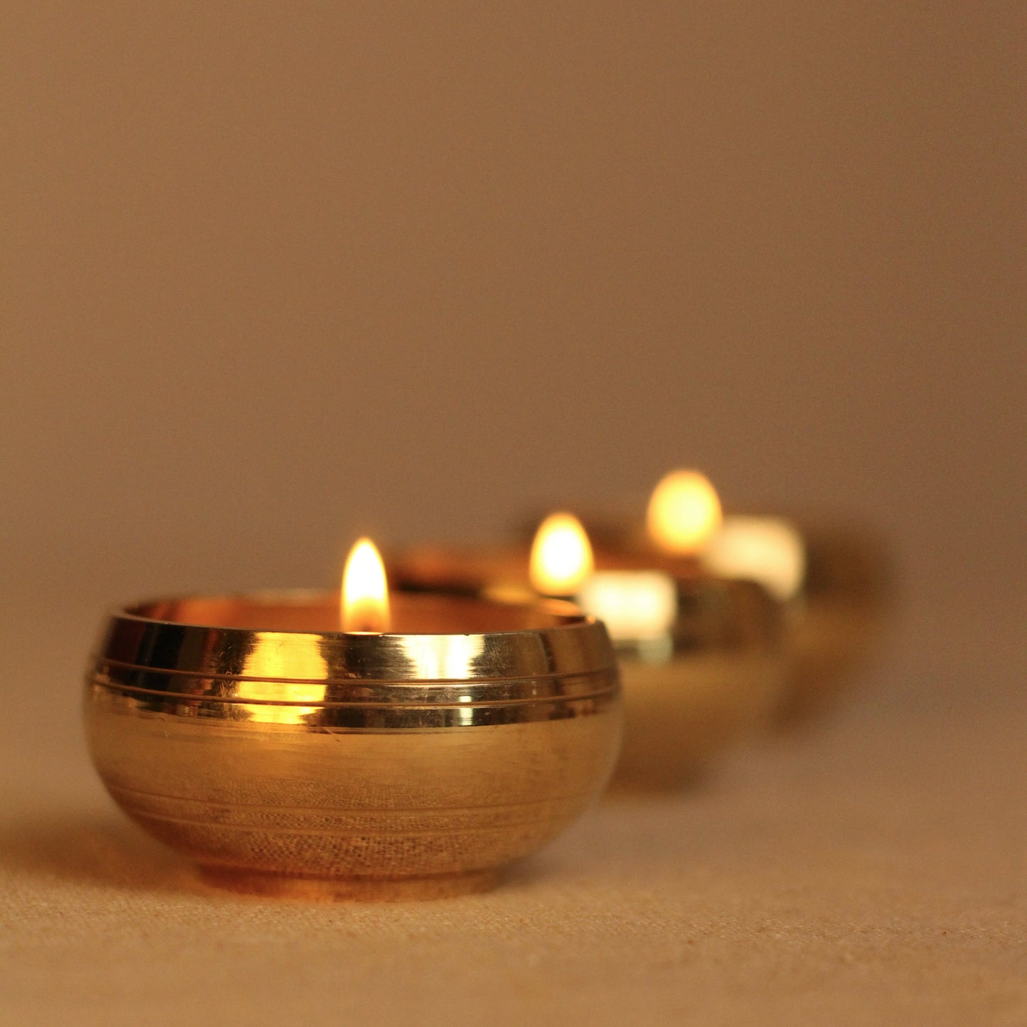 Brass tealight holder lit with candles inside