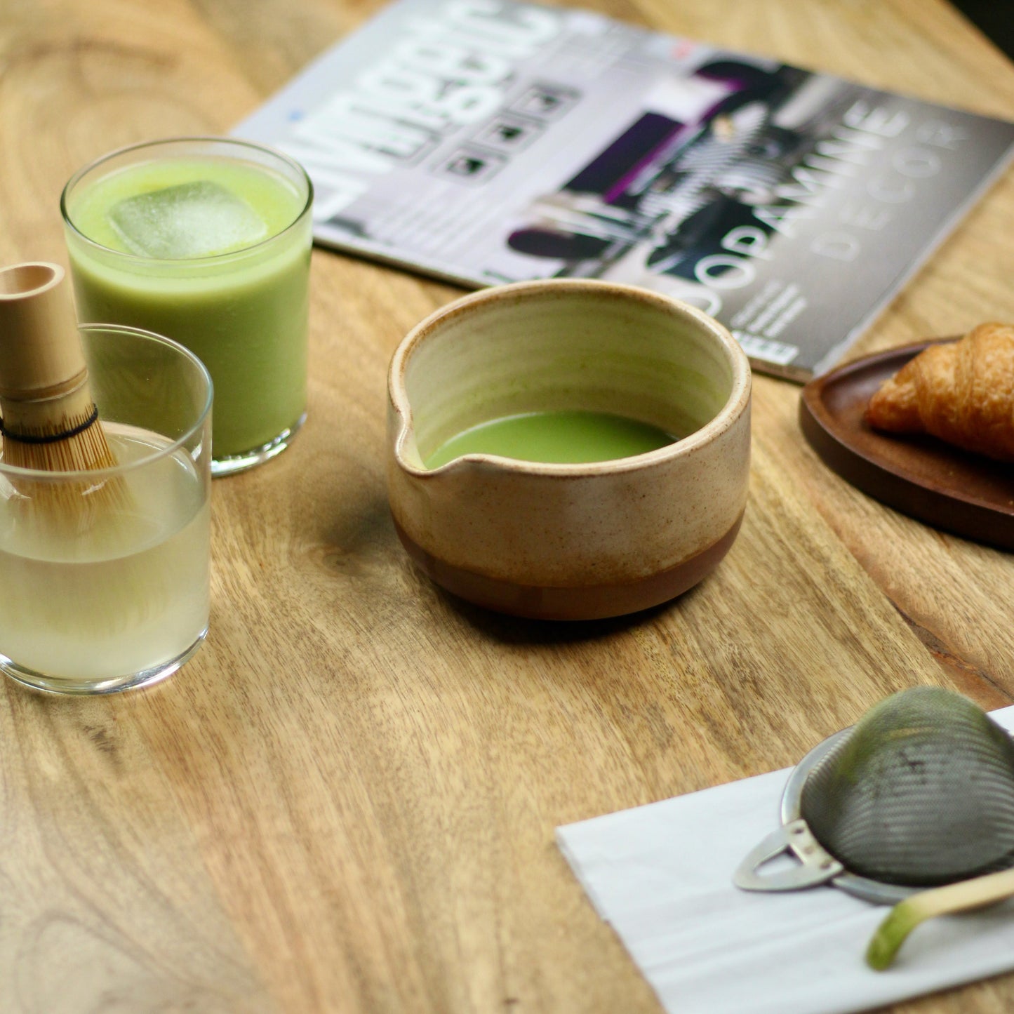 Matcha green tea set on a wooden table with a magazine in the background