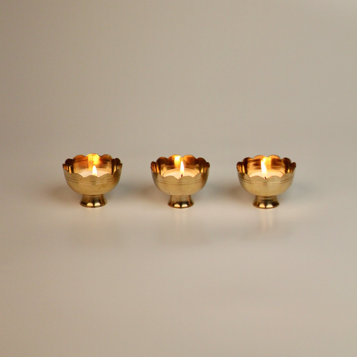 Brass tealight holders placed on backdrop