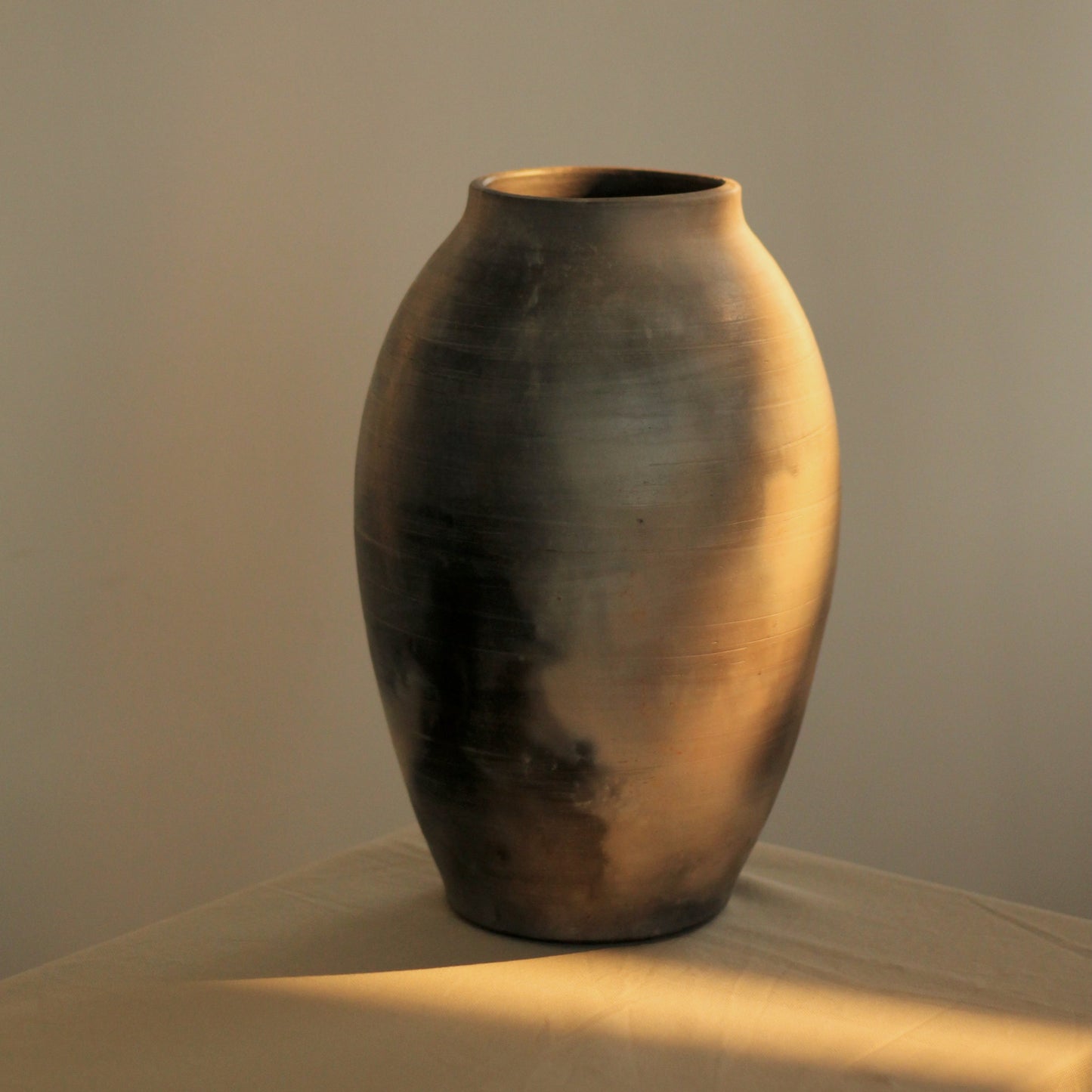 Kaari vase with sunlight touching the surface placed on a table