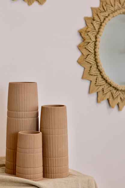 A photo with 3 sizes of vase kept on a table