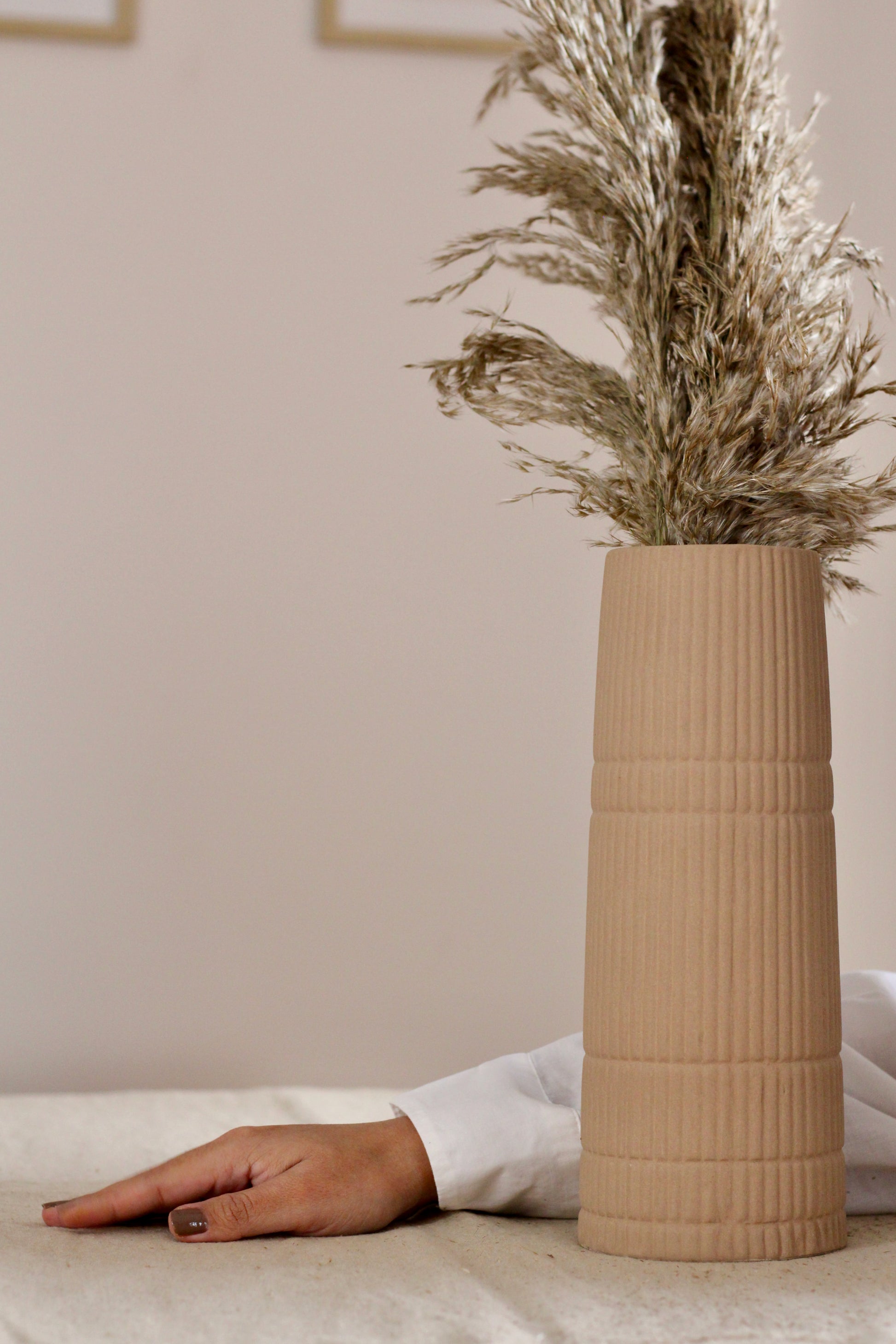 A photo with a vase and a hand setting the table