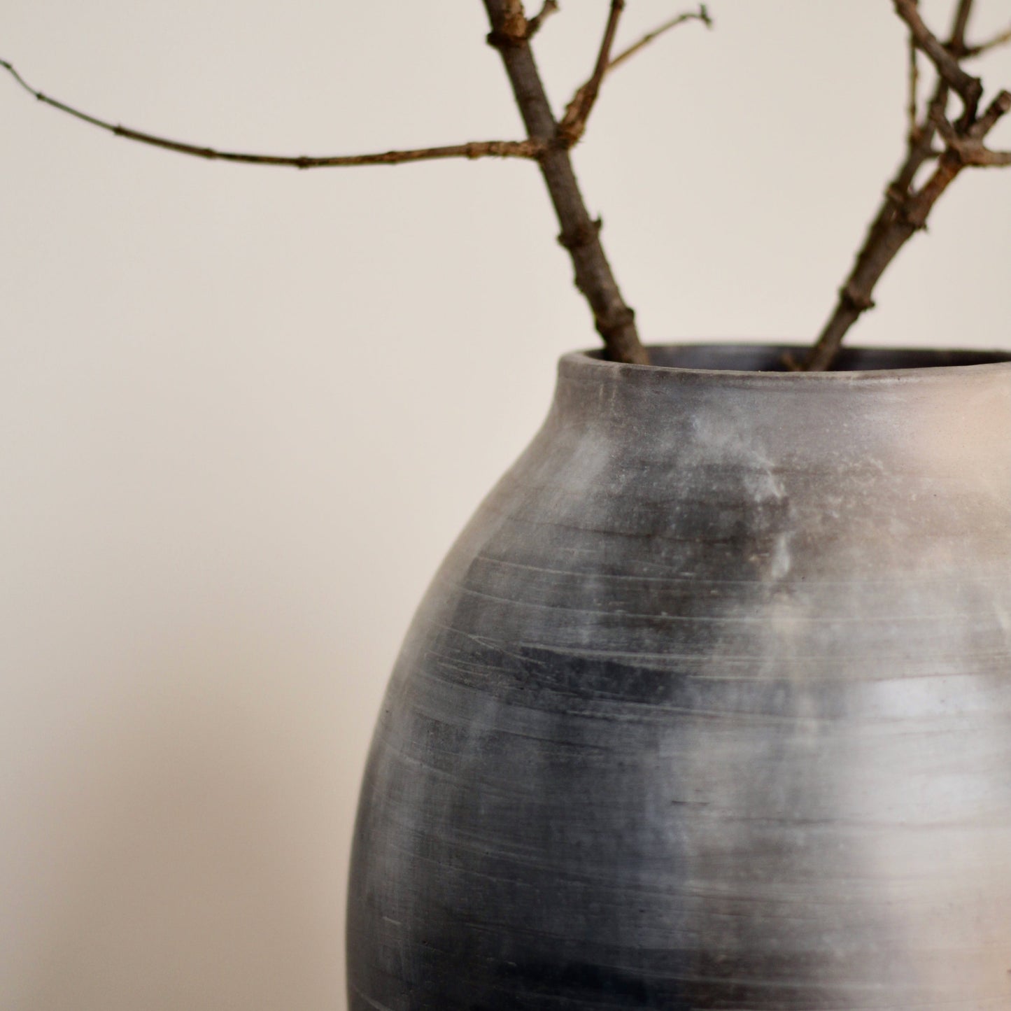 Kaari vase with branches on a plain background