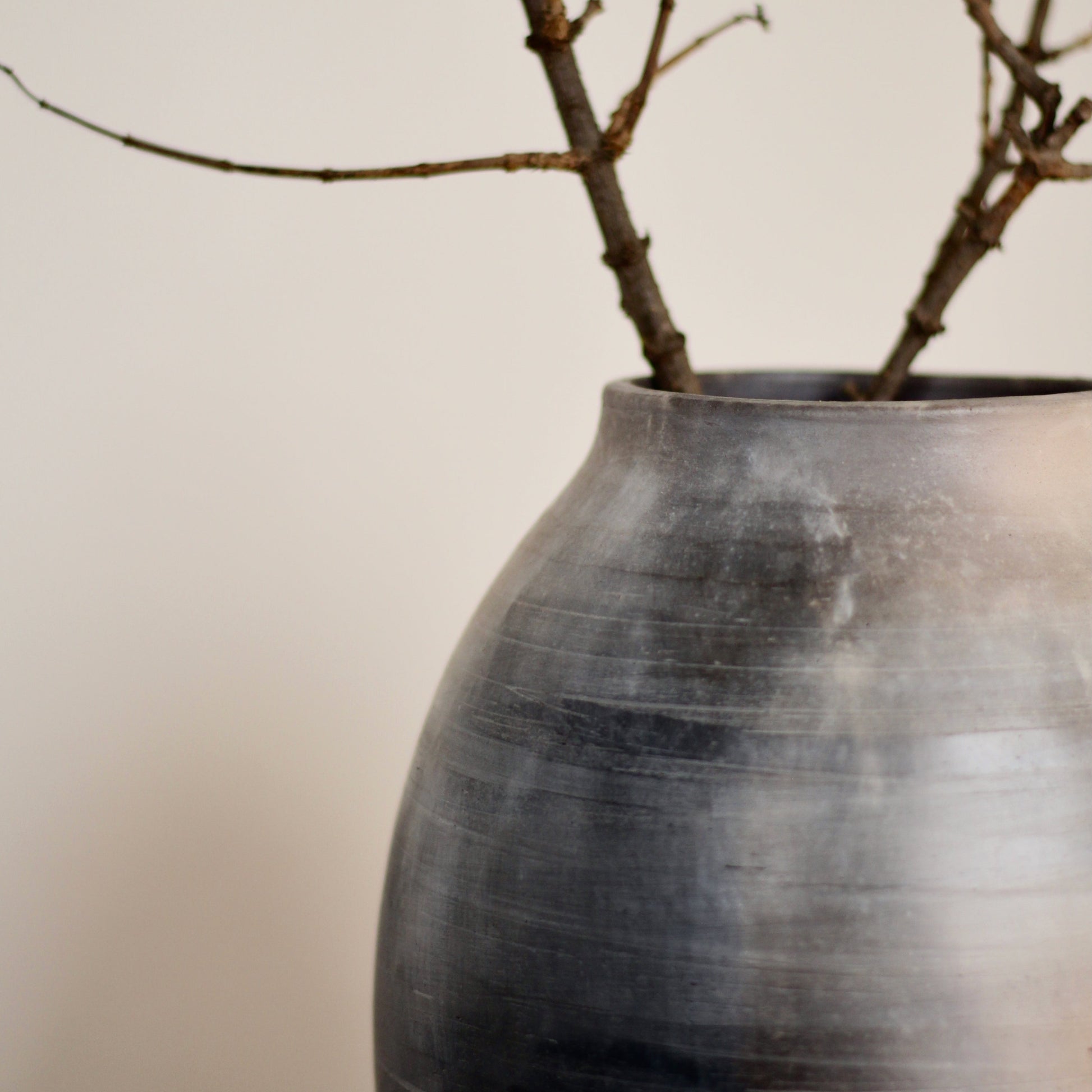 Kaari vase with branches on a plain background