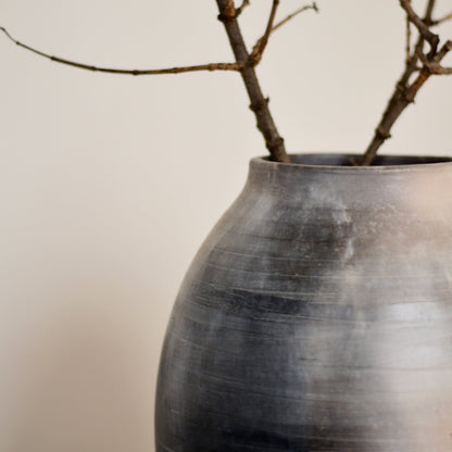 Kaari vase with branches on a plain background