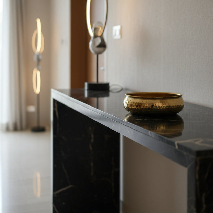 Modern interior with a black marble console table and taksh decor bowl.